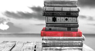 Stapel verschiedener Bücher auf einem alten Holztisch